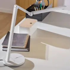 Nowoczesna, biała lampka do laptopa USB na biurku, oświetlająca notatniki.
