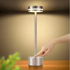 Elegancka lampa stołowa USB z metalową podstawą i dotykowym włącznikiem. Dłoń zbliża się, by ją zapalić.